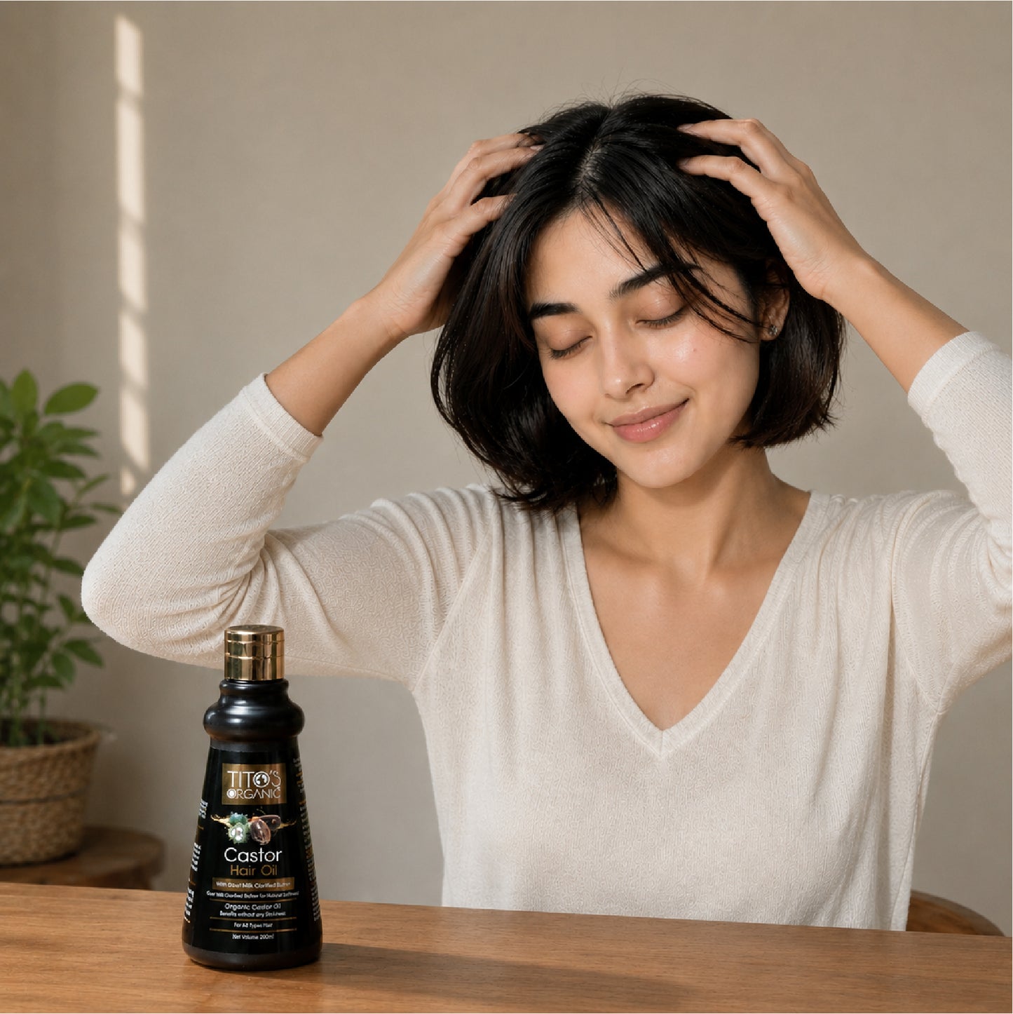 Woman using Tito’s Organic Castor Hair Oil for scalp massage and hair nourishment