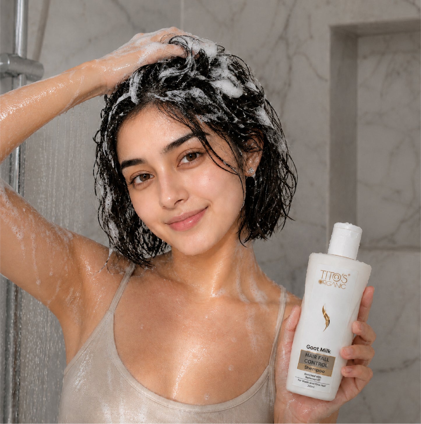 Woman using Tito’s Organic Goat Milk Hair Fall Control Shampoo as part of daily hair care routine
