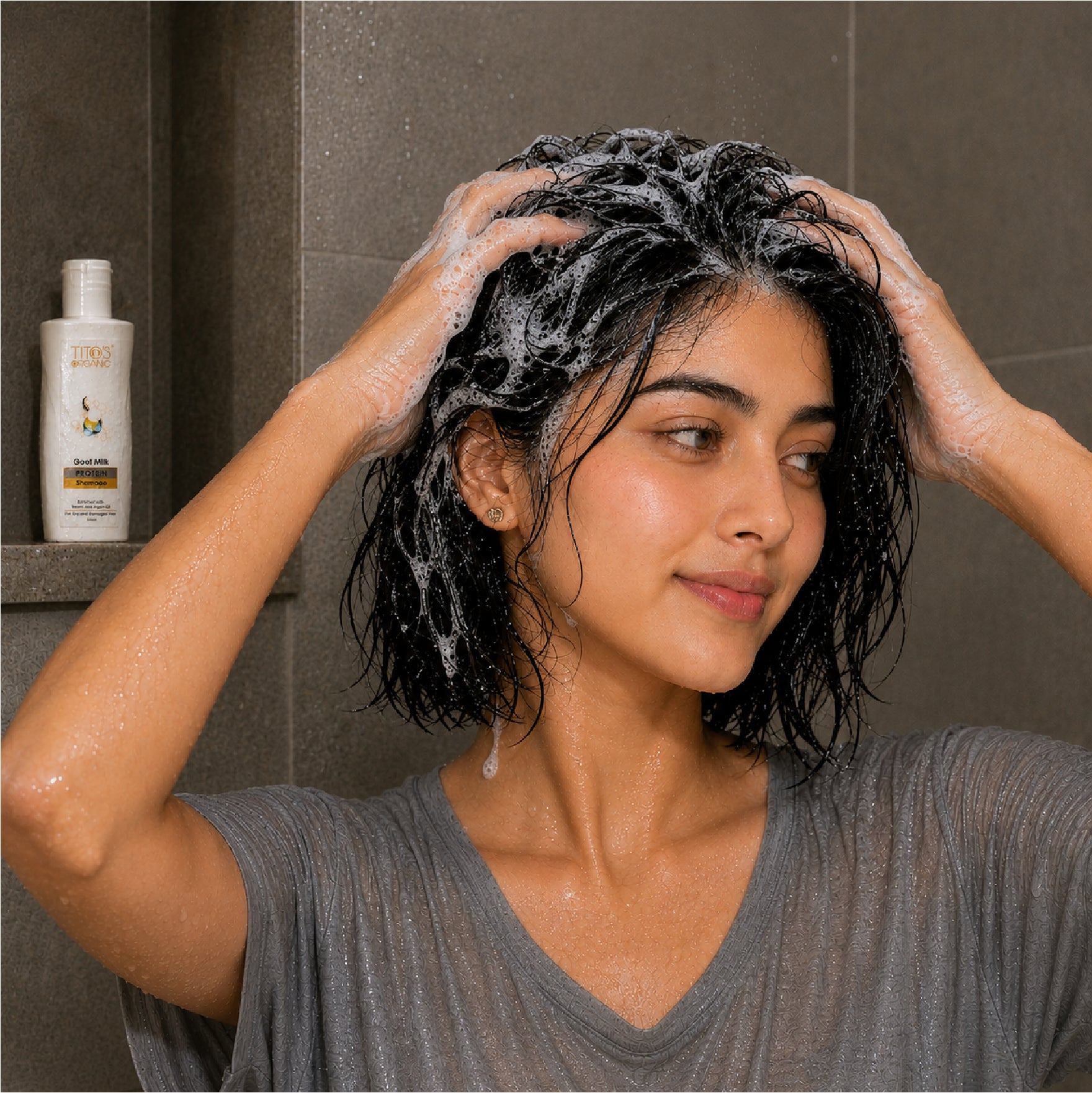 Woman washing hair with Tito’s Organic Goat Milk Protein Shampoo in shower
